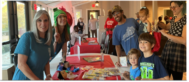 School teachers, parents, and students posed at games and resource table for photo